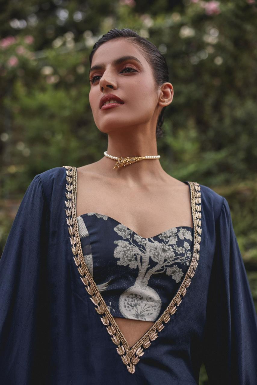 Close-up of antique-gold floral embroidery on the bell-sleeve cuff of the Shajar cotton modal kurta in navy