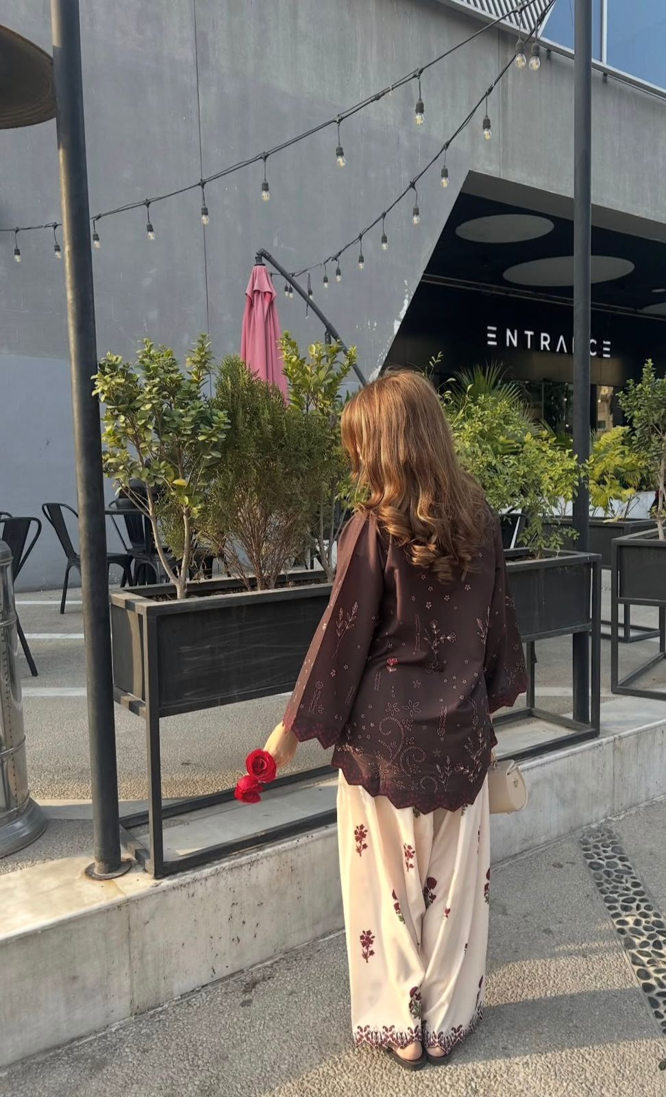Avani chocolate cotton modal kurta with cream rose-printed farsi salwar styled at an outdoor cafe