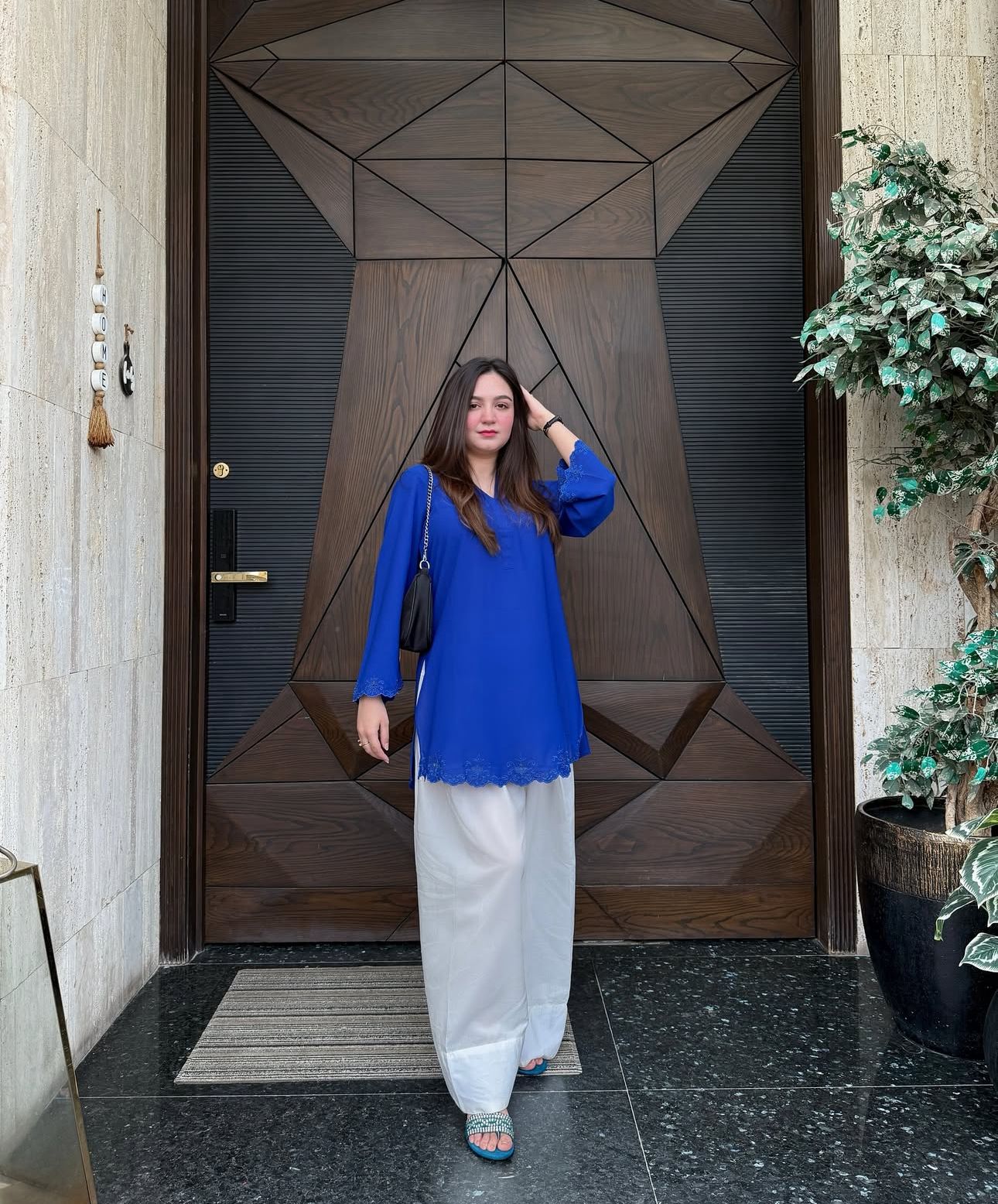Inara cobalt crepe kurta styled with ivory cotton farsi salwar on a styled doorway